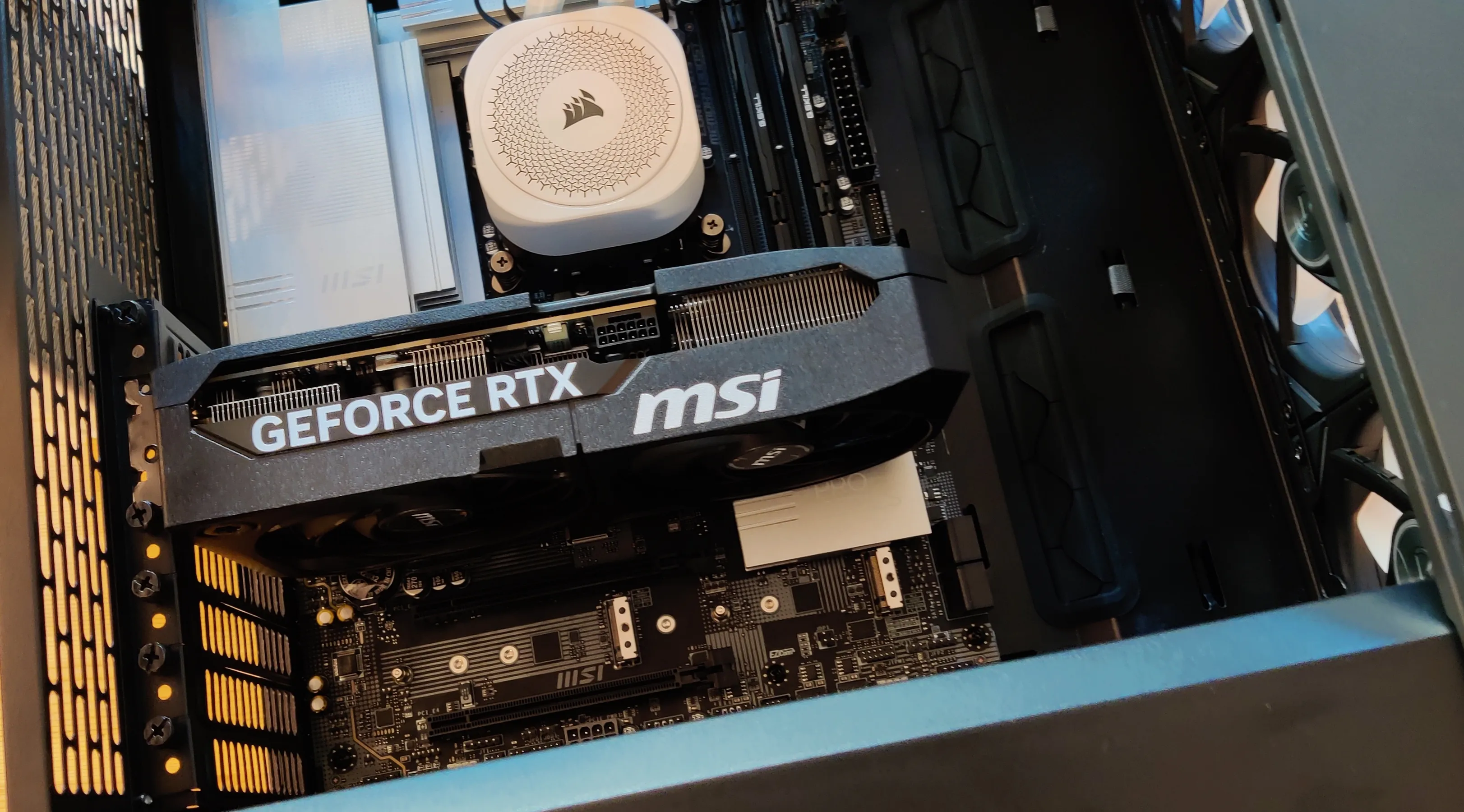 A partially assembled computer, with a black graphics card below a white pump